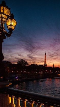 the eiffel tower is lit up at night in paris, france as seen from across the river