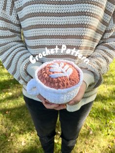 a woman is holding a knitted cupcake in front of her face with the words frosting on it