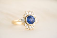 a ring with a blue stone surrounded by small white stones on it's side