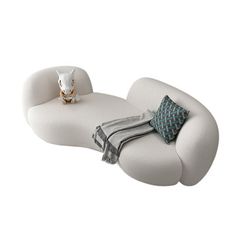 a white couch with pillows on it and a stuffed animal sitting on top of it