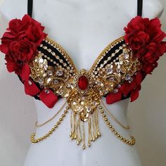 a white mannequin with red flowers and gold chains on it's chest