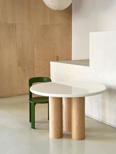 a white table and two green chairs in a room