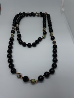 This is a handmade and hand knotted beaded necklace. It measures 38 inches long and is made with black onyx beads, tiny gold beads, hand painted beads. It is a one-of-a-kind piece and a very special one to have in anyone's collection. Handmade Black Onyx Beads, Handmade Black Onyx Beaded Necklaces, Black Beaded Necklace With Round Beads, Black Beaded Long Necklace With Round Beads, Black Long Necklace With Round Beads, Handmade Onyx Beaded Necklaces With Round Beads, Single Strand Onyx Beaded Necklace With Round Beads, Vintage Black Handmade Beaded Necklaces, Bohemian Black Onyx Beaded Necklace