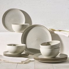 a set of white dishes and cups on a table