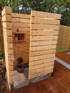 an outdoor shower made out of pallets and wooden slats with shelves on the side