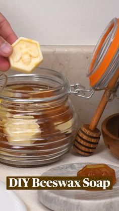 two hands holding chopsticks over a bowl of honey on a wooden table with the words honey above it