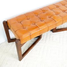 a leather bench sitting on top of a white rug