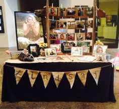 a table that has pictures on it with bunting and photos hanging from the top