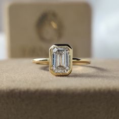 an emerald cut diamond sits on top of a box