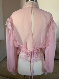 We have here a beautiful silk sheer pink 1910s Victorian/Edwardian blouse trimmed with Chantilly lace trim at the high neck lace collar, trimmed with lace at the cap and the bottom of the long gathered poet sleeves and has an elastic (newer) waist with lace trim. Snaps on both sleeves and at the back neckline and the lower back. There are loops on each side of the gathered waist to thread a pink or white ribbon as a belt. This would have been worn over a camisole. This is a museum quality vintag Edwardian Blouse, Victorian Blouse, Antique Clothing, Chantilly Lace, Lace Collar, Pink Blouse, Night Gown, Lace Trim, Beautiful Outfits