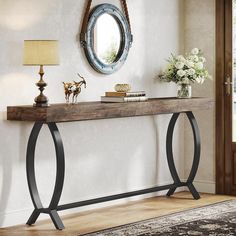 a console table with an oval mirror above it