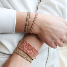 a woman wearing two different bracelets on her arm