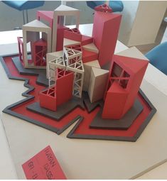 a group of red and white buildings sitting on top of a table next to each other