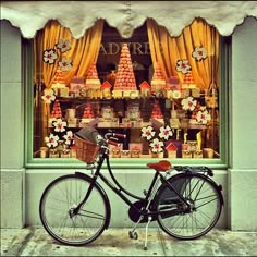 a bicycle parked in front of a store window