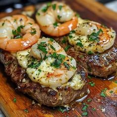 steak with shrimp and shrimp on it sitting on a cutting board