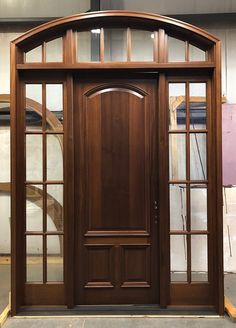 a large wooden door with glass panes on the sides and sidelights above it