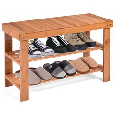 a wooden shoe rack with several pairs of shoes on the top and bottom shelf below