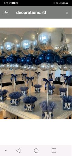 a table topped with lots of blue and silver balloons