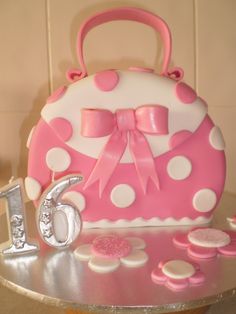 a pink and white cake with polka dots on it's side, sitting on a table