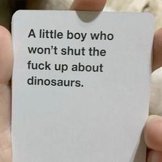 a person holding up a card with the words a little boy who won't shut the f k up about dinosaurs