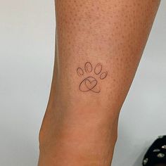 a woman's foot with a small tattoo on her left leg and paw print