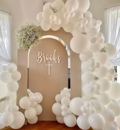 a church entrance decorated with white balloons and greenery