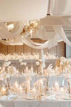 a room filled with lots of tables covered in white cloths