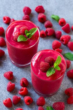 two glasses filled with raspberry smoothie and garnished with mint