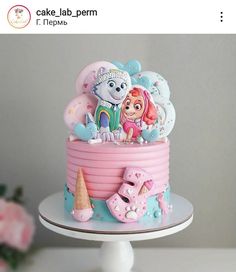 there is a pink cake with cartoon characters on it