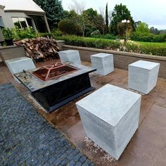 several cement cubes sitting on the ground in front of a building with trees and bushes behind them