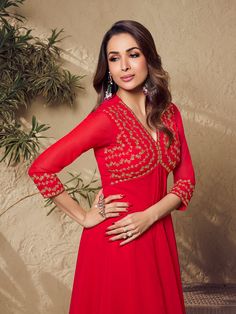 Malaika Arora's red zari embroidered flared kurta with sharara is an elegant winter essential perfect for your ethnic wardrobe. This calf-length A-line piece of pure beauty features a V-neck and three-quarter sleeves that are expertly embroidered with zari and machine weave. Crafted from georgette with crepe inner, it's a timeless addition to your closet. Dry clean only. TOP: Georgette, TOP INNER: Crepe, BOTTOM: Georgette with Crepe Inner, Dry Clean Red Anarkali Set With Chikankari Embroidery For Party, Festive V-neck Kurta With Zari Work, Festive V-neck Lehenga, Festive Georgette Maxi Kurta, V-neck Resham Embroidered Sharara For Diwali, Diwali V-neck Sharara With Resham Embroidery, Festive Maxi Length Georgette Kurta, Festive V-neck Kurta For Diwali, Red V-neck Kurta For Festivals