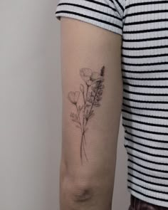 a woman's arm with a flower tattoo on the left side of her arm