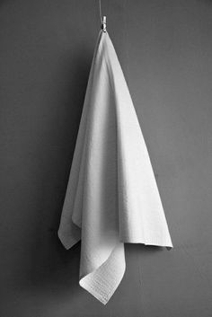 a white towel hanging from a hook on a wall