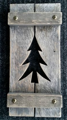 a wooden plaque with a black tree on it