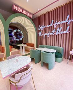 the interior of a restaurant with pink and green decor