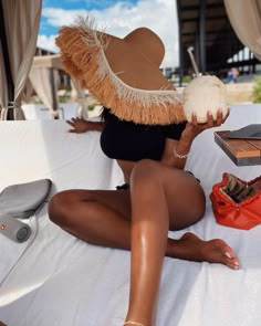 a woman sitting on top of a bed holding a coconut