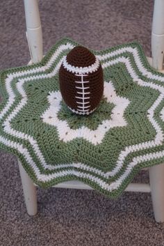 a crocheted afghan with a football sitting on it's back end in the shape of a star