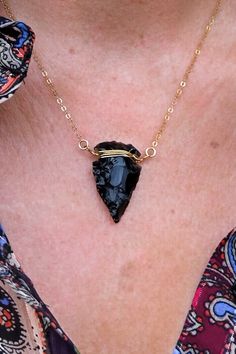 "This Obsidian Arrowhead necklace has the most beautiful angles. Aside from the perfect everyday necklace that will go with anything, this beauty is your reminder that you are limitless. Would look so amazing with our Herkimer gold choker. The arrowhead is a powerful symbol known throughout history. Wearing an arrowhead around your neck is a symbol of protection & strength. It's also an icon of courage, protecting its wearer from negative energy. ▲ Obsidian arrowhead pendant ▲ 14k gold fill Handmade Black Arrowhead Necklace, Arrowhead Wire Wrapped Necklaces For Gifts, Wire Wrapped Arrowhead Necklace For Gift, Spiritual Arrowhead Necklace Gift, Handmade Spiritual Arrowhead Necklace, Adjustable Arrow Jewelry As Gift, Adjustable Arrowhead Necklace Gift, Handmade Arrowhead Jewelry Gift, Mens Gold Chain Necklace