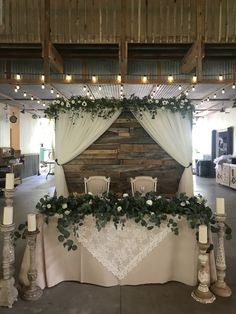 the table is set up with white flowers and greenery for an elegant wedding reception