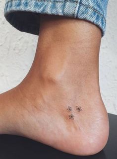 a person's foot with three small flowers on the bottom of their toe and one is