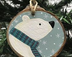 a wooden ornament with a polar bear wearing a scarf on it's neck