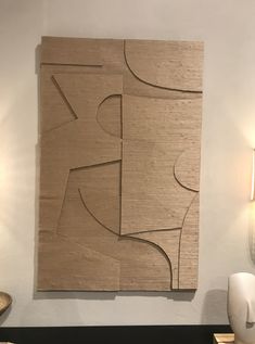 an abstract wooden artwork hangs on the wall