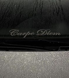 the hood of a car that is covered in raindrops with carppe diem written on it