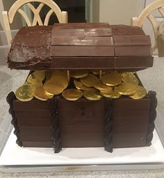 there is a cake made to look like a chest with gold coins in it and chocolate on top