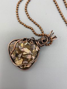 Triangular shaped stone with coppers, gold, beige, and pinks -- looks like an abstract painting! Stone is wire wrapped in oxidized copper to make it antique-looking. The design has a pretty rosette at the base of the bail. Pendant is 2 inches tall and 1.5 inches wide and comes with a free chain. Gold Copper Wire Jewelry With Gemstones, Hand Wrapped Copper Gold Necklace, Hand Wrapped Gold Copper Necklace, Gold Gemstone Jewelry With Copper Wire, Gold Jasper Jewelry For Jewelry Making, Earthy Gold Jewelry Made Of Copper, Artisan Rose Gold Jewelry, Earthy Gold-colored Copper Jewelry, Earthy Gold Copper Jewelry