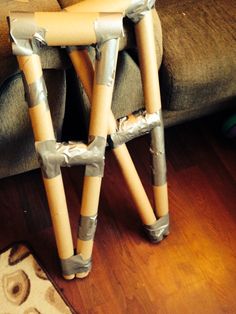 two wooden sticks sitting on top of each other in front of a couch with the seat up