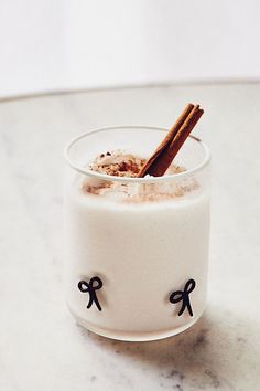 a glass filled with milk and cinnamon on top of a table