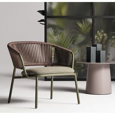 a chair sitting in front of a window next to a table with a plant on it