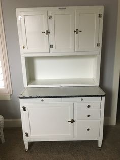 a white cabinet with two doors and drawers