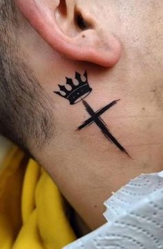 a man with a crown tattoo on his neck and behind the ear is a cross